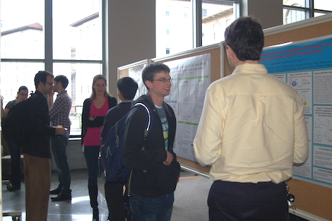 Students standing around and talking at a symposium